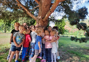 Dzieci przytulające drzewo