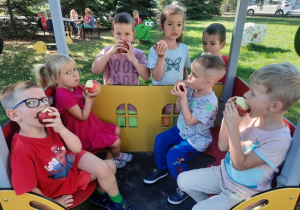 Dzieci jedzące jabłka w ogrodzie
