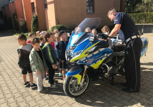 Przedszkolaki podziwiają policyjny motocykl
