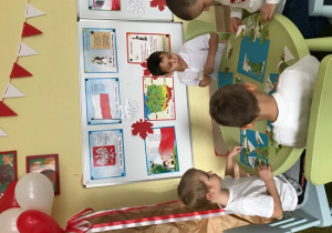 Chłopcy układają mapę Polski z puzzli
