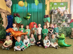 Dzieci na tle dekoracji z okazji Dnia Dinozaura