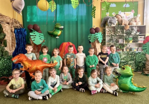 Dzieci na tle dekoracji z okazji Dnia Dinozaura