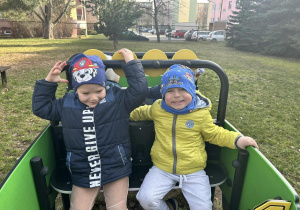 Chłopcy w samochodzie w ogrodzie przedszkolnym