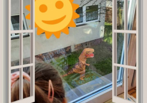 Dzieci oglądają dinozaura spacerującego po ogrodzie