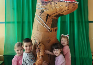 Dzieci przytulające się do dinozaura
