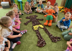 01 Dzieci z ułożonym z kasztanów Plastusiem.