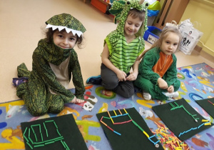 Maja, Wiktor i Maja układają z patyczków dinozaury