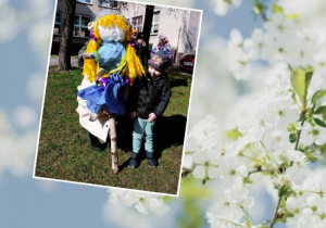 Fryderyk stoi obok przedszkolnej kukły Marzanny w ogrodzie przedszkolnym