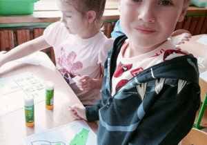 Olek prezentuje szablon kalarepy wyklejony zielonymi kawałkami papieru