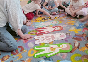 Dzieci ogladają puzzle przedstawiające układy z jakich zbudowany jest człowiek