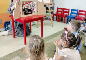 Dzieci słuchają bajki pt.: "Noc w bibliotece"