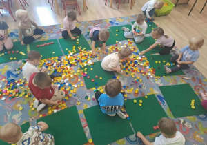 Motylki układają z nakrętek różne wzory.