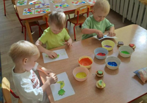 Motylki tworzą pracę plastyczną z ziemniaczanych stempli.
