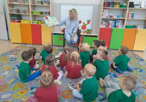 Pani Dorota czyta książkę dzieciom o Cliffordzie.