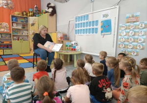 Mama Marcela czyta książkę dzieciom.