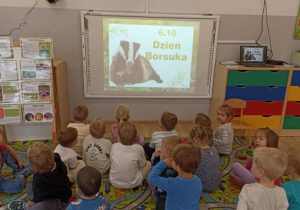 Dzieci oglądają film edukacyjny o borsuku.