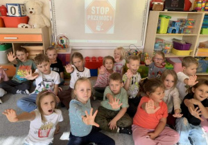 Dzieci z grupy Biedronek pokazują gestem znak Stop.