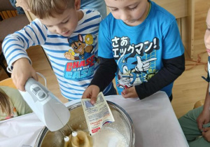 Chłopcy miksują składniki na ciasto.