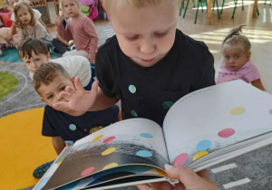 Fryderyk ogląda książkę z kropkami.