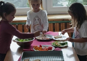 Dzieci wybierają składniki na kanapki.