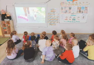 Dzieci oglądają film edukacyjny o psach.
