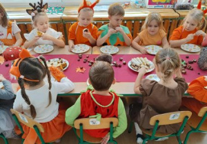 Dzieci jedzą smaczny poczęstunek.