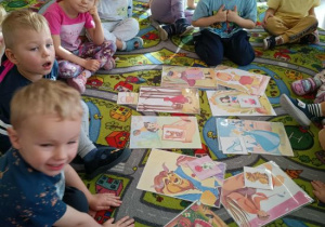 Dzieci oglądają ilustrację z różnych bajek.