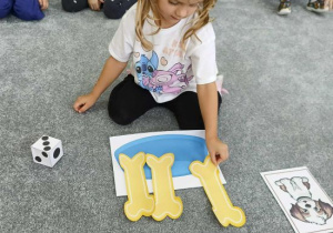 Dziewczynka przelicza kości dla pieska.