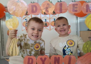 Chłopcy pozują w dyniowej fotobudce.