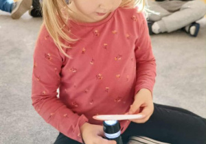 Ola podświetla papierową dynię.