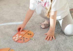 Dziewczynka rozwiązuje łamigłówkę matematyczną.