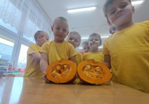 Chłopcy prezentują przekrojoną dynię.