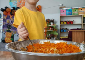 Chłopiec miesza składniki na ciasto dyniowe.