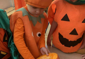 Olek wydrąża dynię.