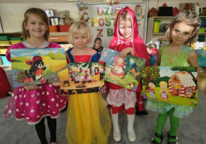 Dziewczynki prezentują ilustracje z bajek.