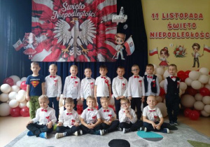 Chłopcy z grupy Pszczółek na tle dekoracji z okazji Święta Niepodległości.