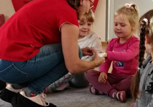 Pani pielęgniarka bandażuje rękę Zuzi.