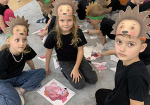 Dzieci układają puzzle z jeżami.