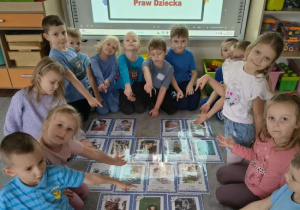 Dzieci wskazują swoje prawa na planszach.