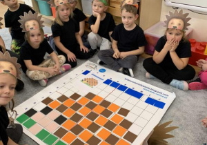 Dzieci prezentują jeża ułożonego na macie do kodowania.