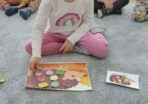 Dziewczynka koduje jabłka na jeżu.