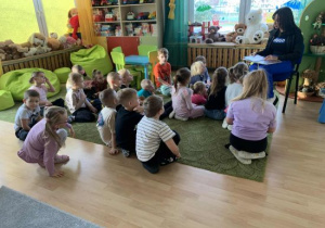 Dzieci z zaciekawieniem słuchają czytanych opowiadań.