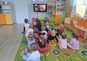 Dzieci oglądają bajkę z Myszką Miki.
