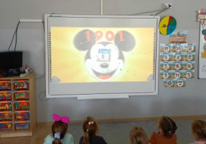 Dzieci oglądają film dotyczący historii powstania Myszka Miki.