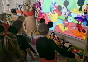 Dzieci tańczą razem z Myszką Miki.