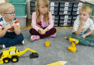 Dzieci mają przed sobą przedmioty w kolorze żółtym.