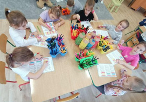 Grupa dziewczynek koloruje kredki wg podanego rytmu.