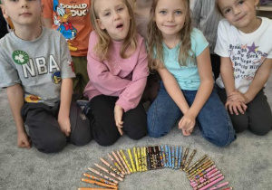 Dzieci prezentują kolorowe koło z kredek.