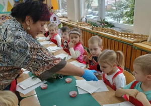 Pani daje powąchać przyprawę do piernika dziewczynce.