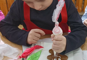 Chłopiec dekoruje piernika.